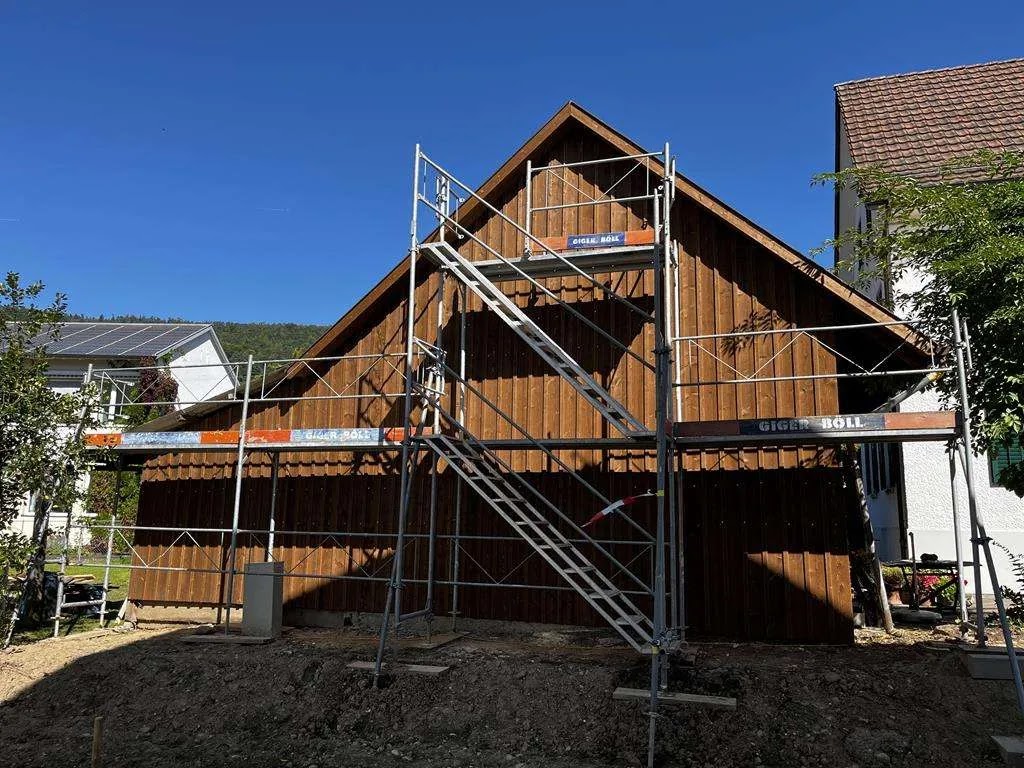 Holzfassade eines Giebelhauses mit Gerüst