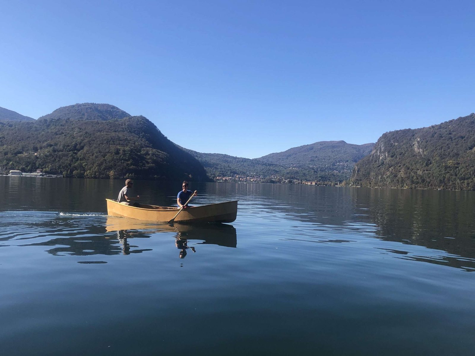 Holzkanu auf dem See mit Bergen im Hintergrund