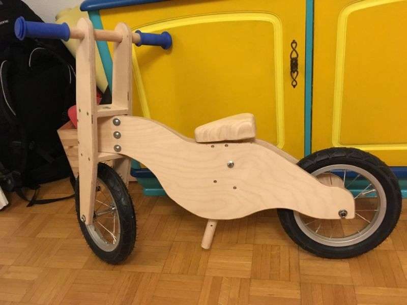 Handgemachtes Holzlaufrad vor einer Mauer