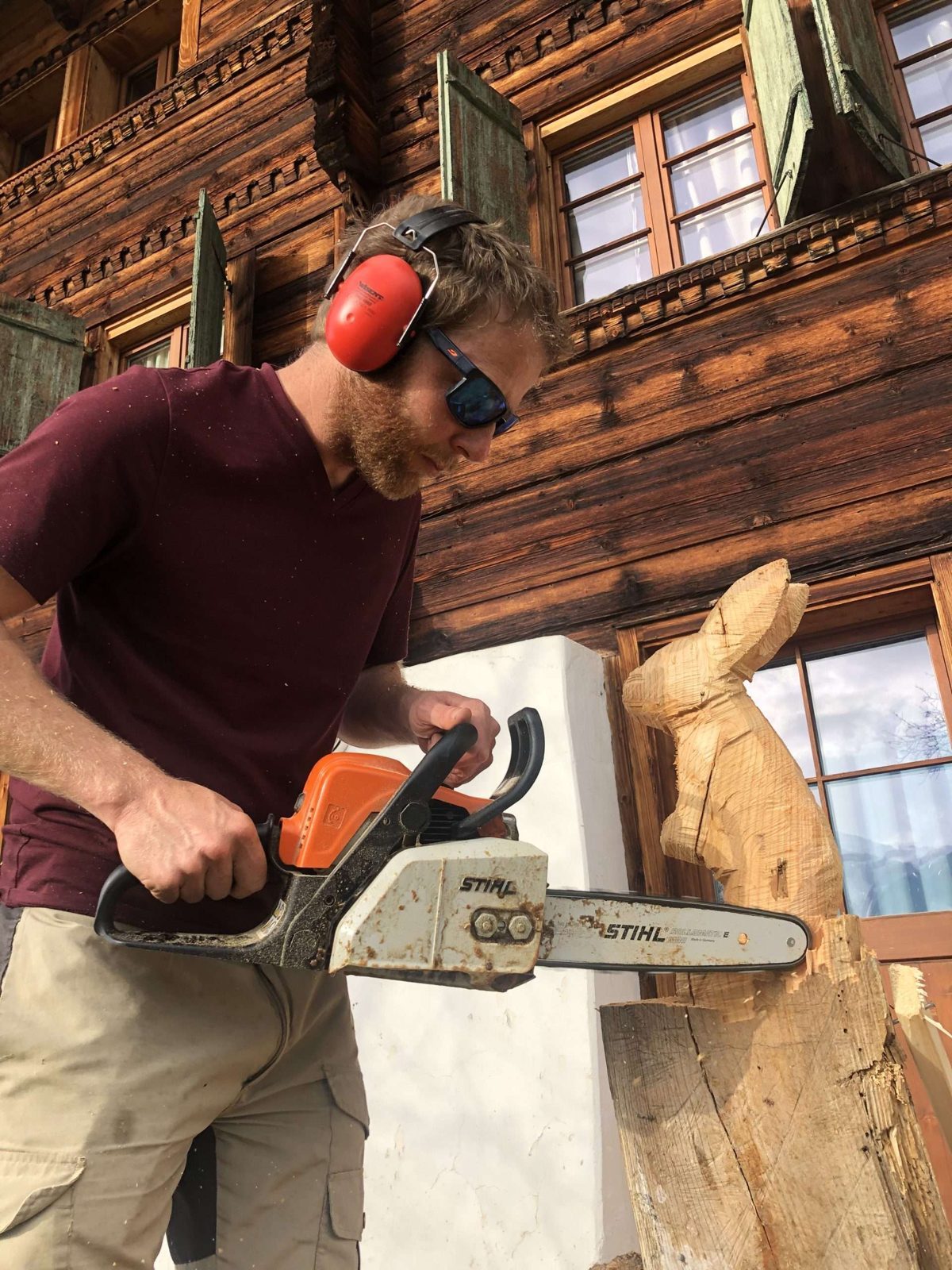 Mats mit Gehörschutz und Motorsäge bei der Holzarbeit